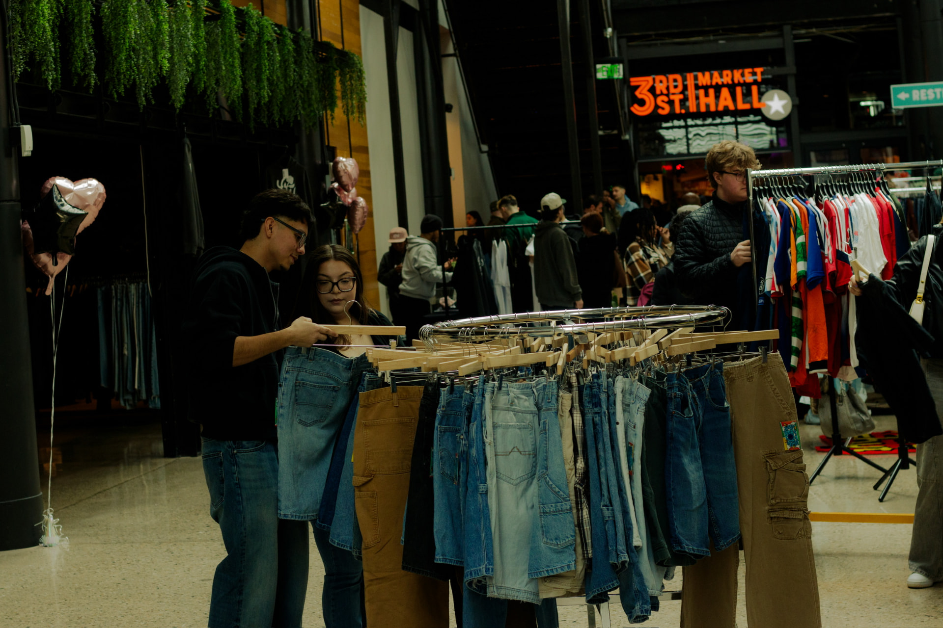 Shoppers browsing vintage clothing racks at Third Street Market Hall